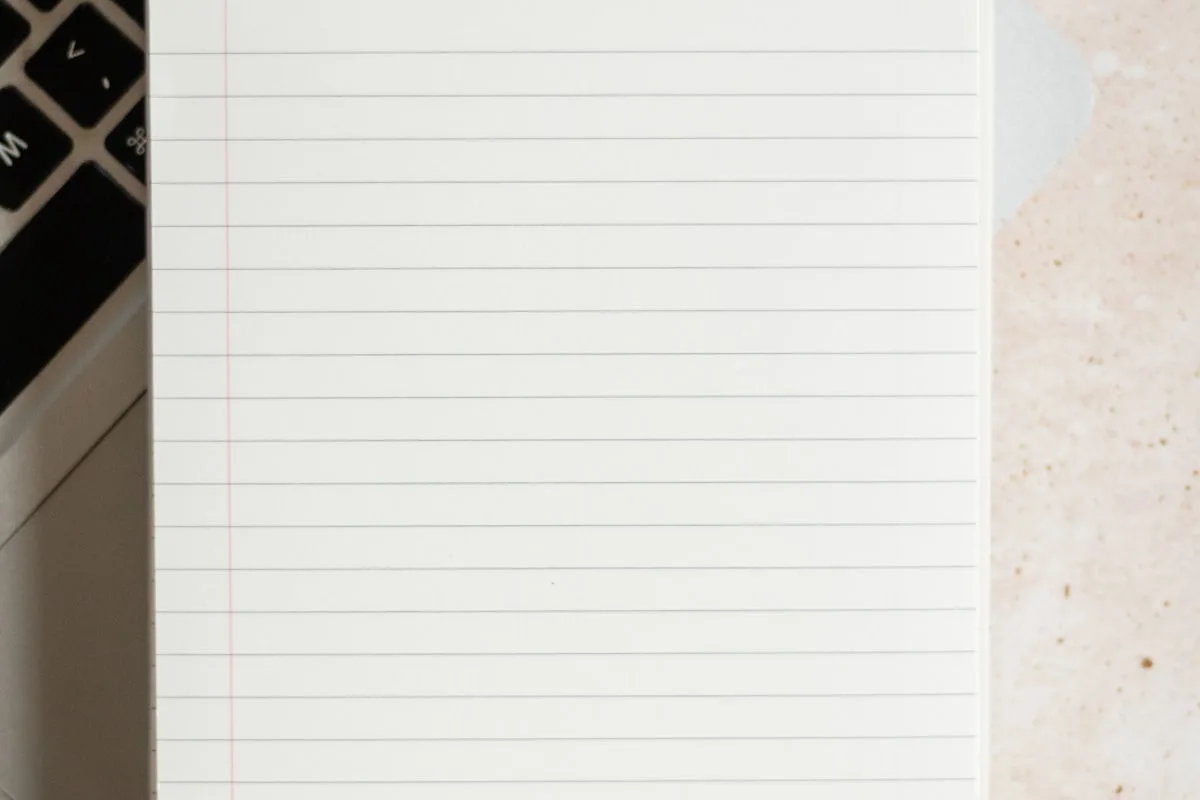 Bloc-notes posé sur un ordinateur portable pour la rédaction de contenu